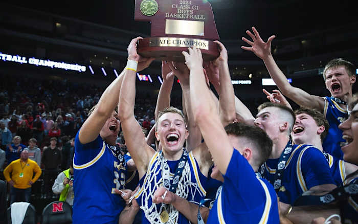 Marcus Glock, center, and his Wahoo teammates raise the trophy in celebration moments after defeating Auburn for the Class C-1 state title on Saturday in Lincoln. Photo by @wahoopublic on X.